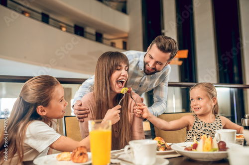 Smiling family sitting at the table and having fun