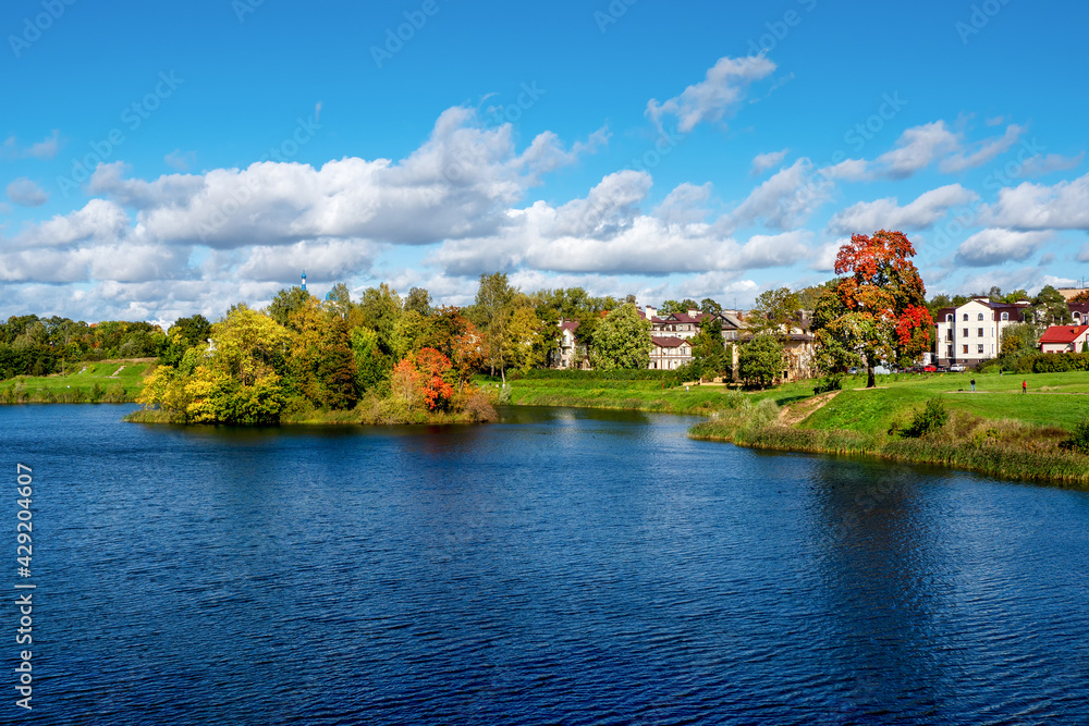 Beautiful panoramic autumn landscape with bright trees on the lake shore