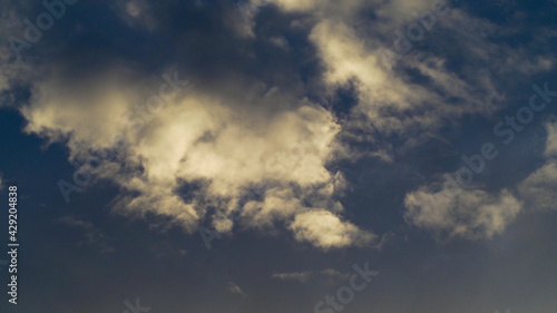 Teintes jaunâtres sous des cumulus, pendant le coucher du soleil