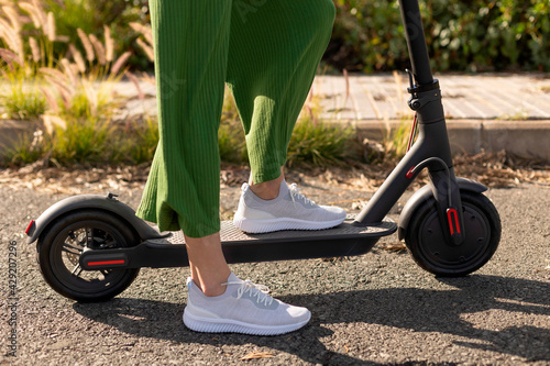 An unrecognisable woman on an electric scooter