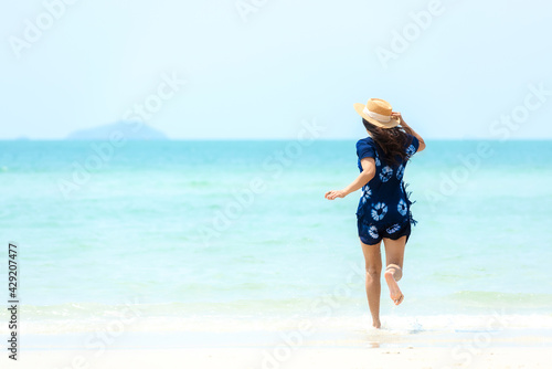Summer vacations. Lifestyle woman relax and chill on beach background.  Asia happy young people running on the wave sea  summer trips walking enjoy  tropical beach