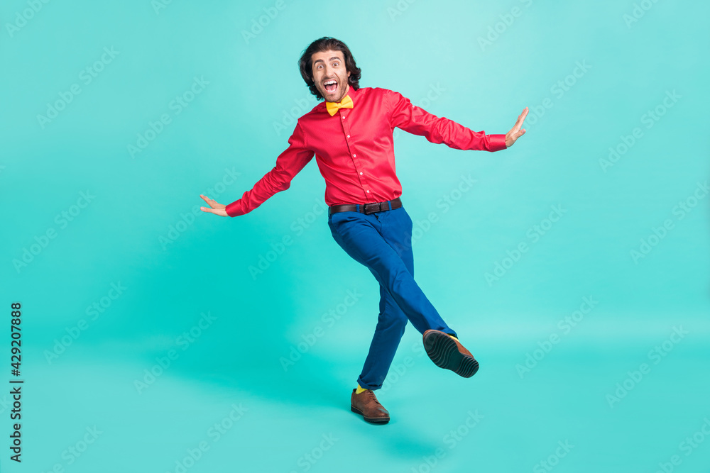 Full length photo of charming funky happy young man dance amazed isolated on pastel teal color background Full length photo of charming funky happy young man dance amazed isolated on pastel teal color background