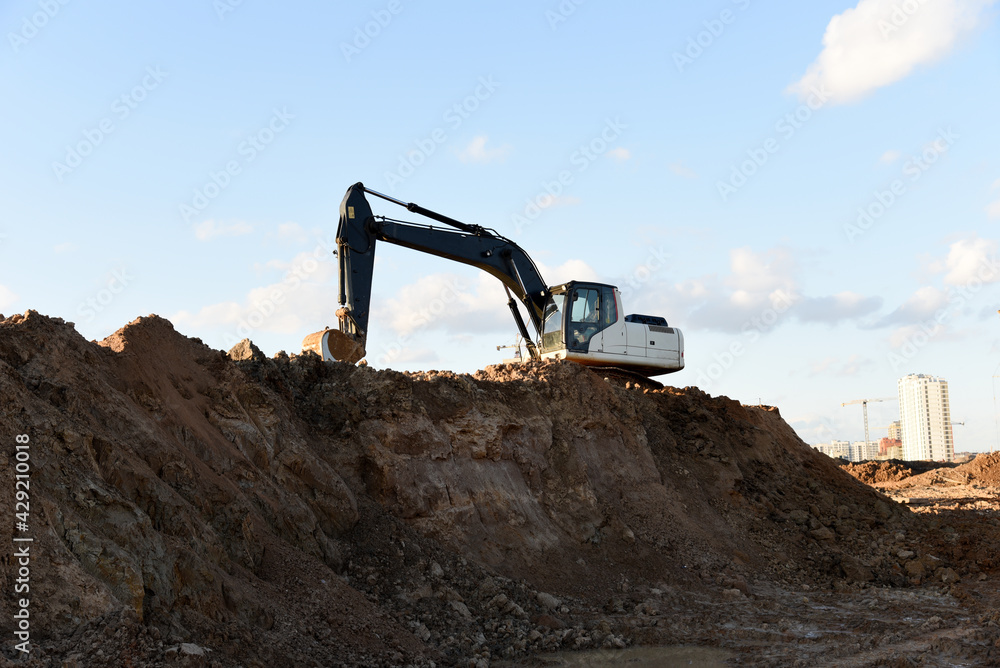 Excavator dig the trenches at a construction site. Trench for laying external sewer pipes. Sewage drainage system for a multi-story building. Digging the pit foundation. Excavator dig the trenches at a construction site. Trench for laying external sewer pipes. Sewage drainage system for a multi-story building. Digging the pit foundation.