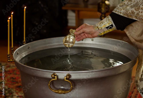 Prist's hand with holy water for baptism photo