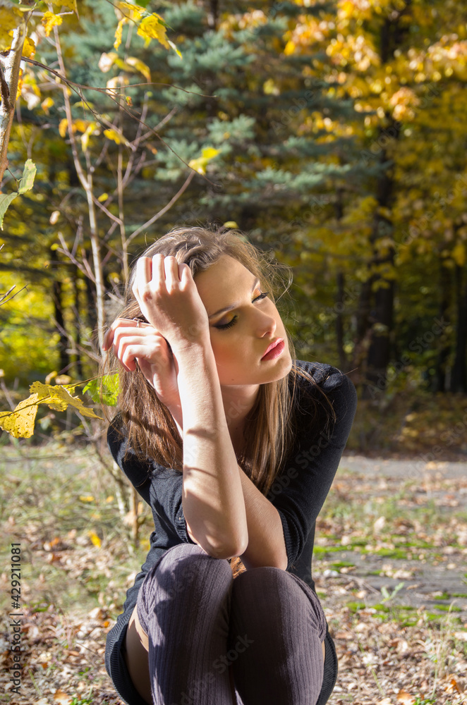 Portrait of a girl in an autumn park against a background of yellow foliage. Blurred background. Selective focus. Portrait of a girl in an autumn park against a background of yellow foliage. Blurred background. Selective focus.