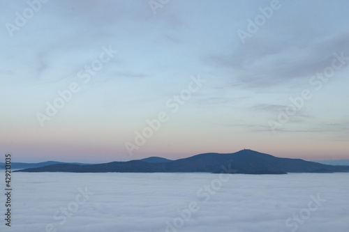 Lysa Hora protrudes with a sea of clouds and rises at sunset. Beautiful Beskydy mountains in eastern Bohemia in the middle of Europe