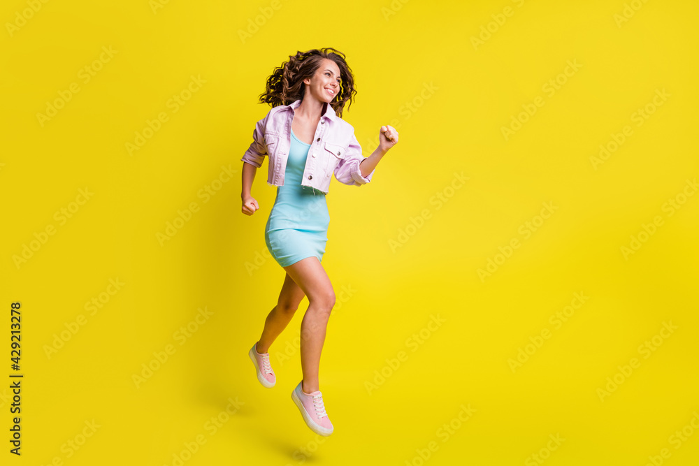 Full size profile portrait of attractive cheerful lady running look empty space isolated on yellow color background Full size profile portrait of attractive cheerful lady running look empty space isolated on yellow color background