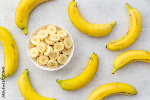 Many banana slices with whole bananas. Top view