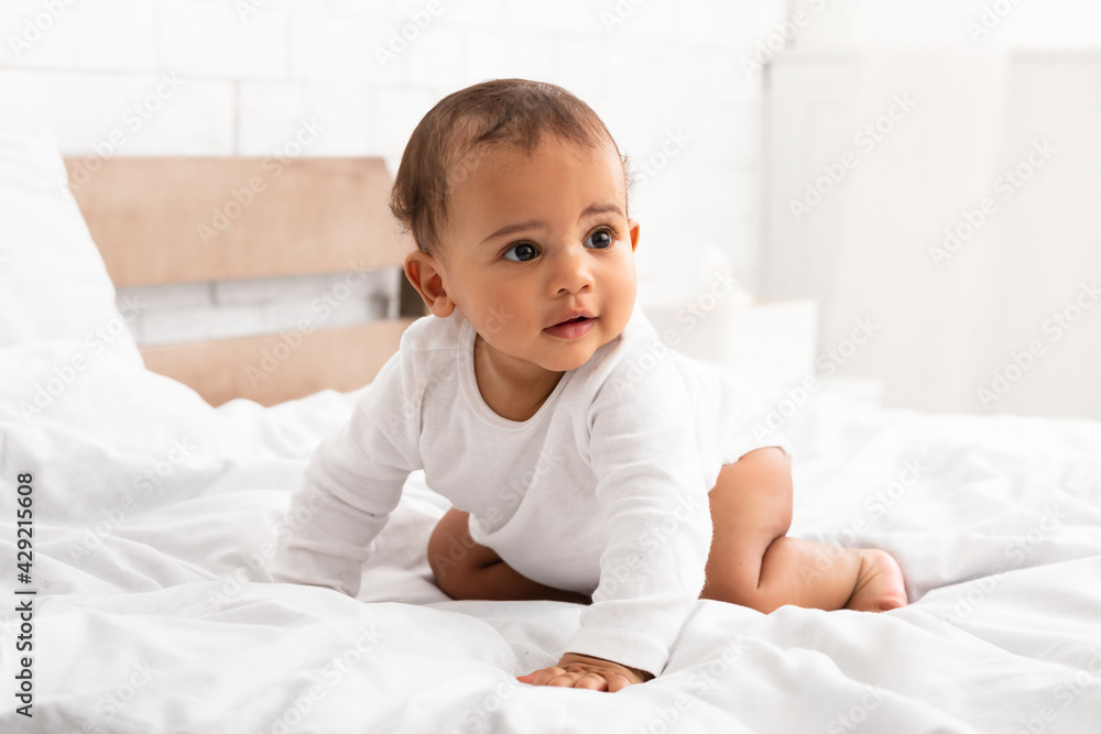 African Little Baby Crawling On Bed Looking Aside In Bedroom African Little Baby Crawling On Bed Looking Aside In Bedroom