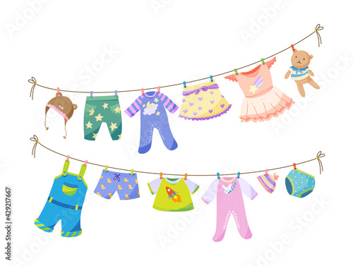 Baby fabric apparel. Baby girls and boys clothes hanging on clothesline. Drying children clothes and accessories after washing on rope. Shorts, socks, sweater, hat, toys, T-shirt, sarafans