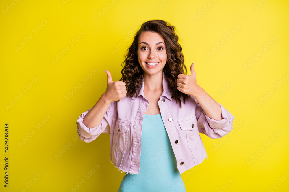 Portrait of pretty cheerful glad wavy-haired girl showing double thumbup cool isolated over bright yellow color background Portrait of pretty cheerful glad wavy-haired girl showing double thumbup cool isolated over bright yellow color background