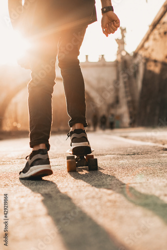 detail of sneakers placed on an urban skateboard at sunset