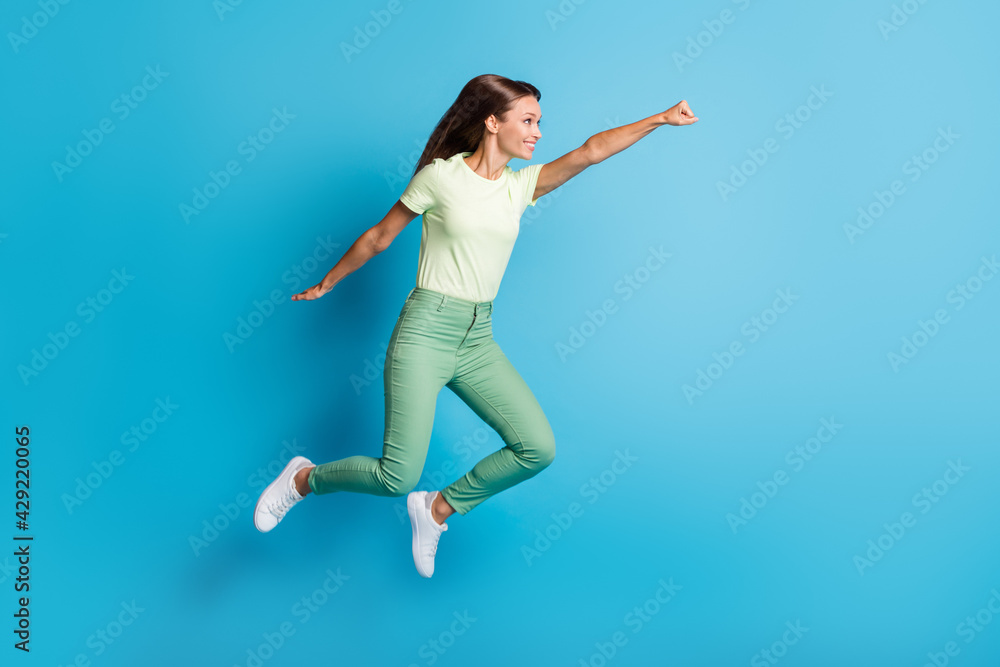 Full length body size photo of pretty girl flying super woman in casual outfit isolated on bright blue color background