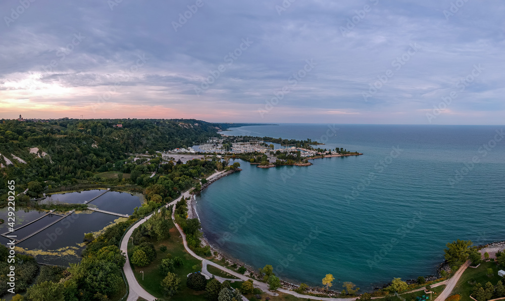 Scarborough Bluffs park aerial panorama shot from above with drone, one of the Toronto city attractions. Summer day, high white clay cliffs and turquoise water of Lake Ontario. Wide angle shot.