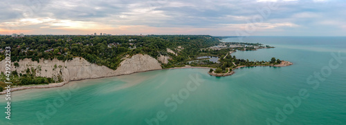Scarborough Bluffs park aerial panorama shot from above with drone, one of the Toronto city attractions. Summer day, high white clay cliffs and turquoise water of Lake Ontario. Wide angle shot. photo