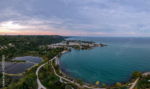 Scarborough Bluffs park aerial panorama shot from above with drone, one of the Toronto city attractions. Summer day, high white clay cliffs and turquoise water of Lake Ontario. Wide angle shot. © Elena Berd