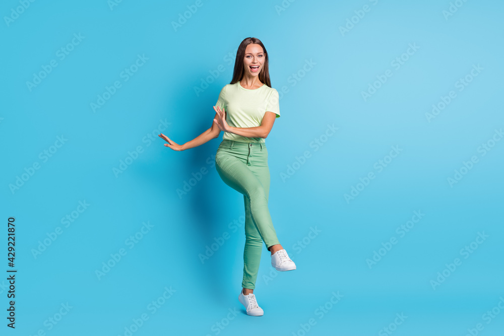 Full size photo of impressed brunette lady dance wear t-shirt trousers sneakers isolated on blue color background