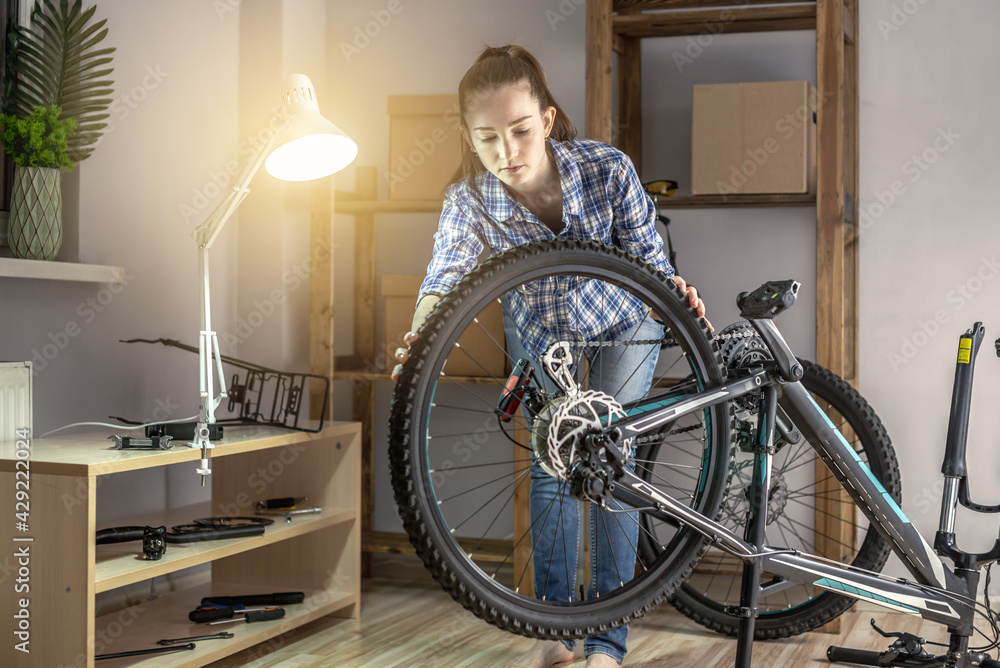 Woman is performing maintenance on his mountain bike. Concept of fixing and preparing the bicycle for the new season Woman is performing maintenance on his mountain bike. Concept of fixing and preparing the bicycle for the new season