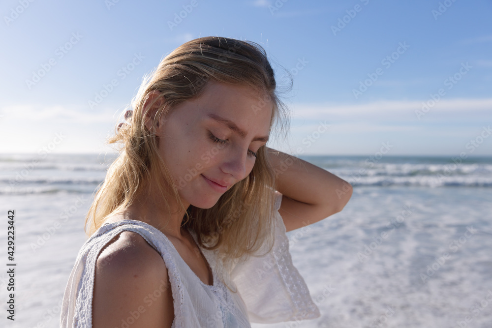 Smiling caucasian woman standing with eyes closed at the beach Smiling caucasian woman standing with eyes closed at the beach