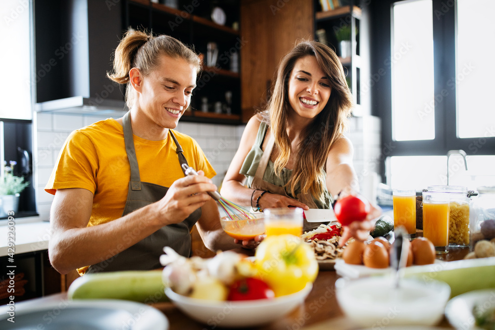 Happy people, couple cooking food together in their loft kitchen at home