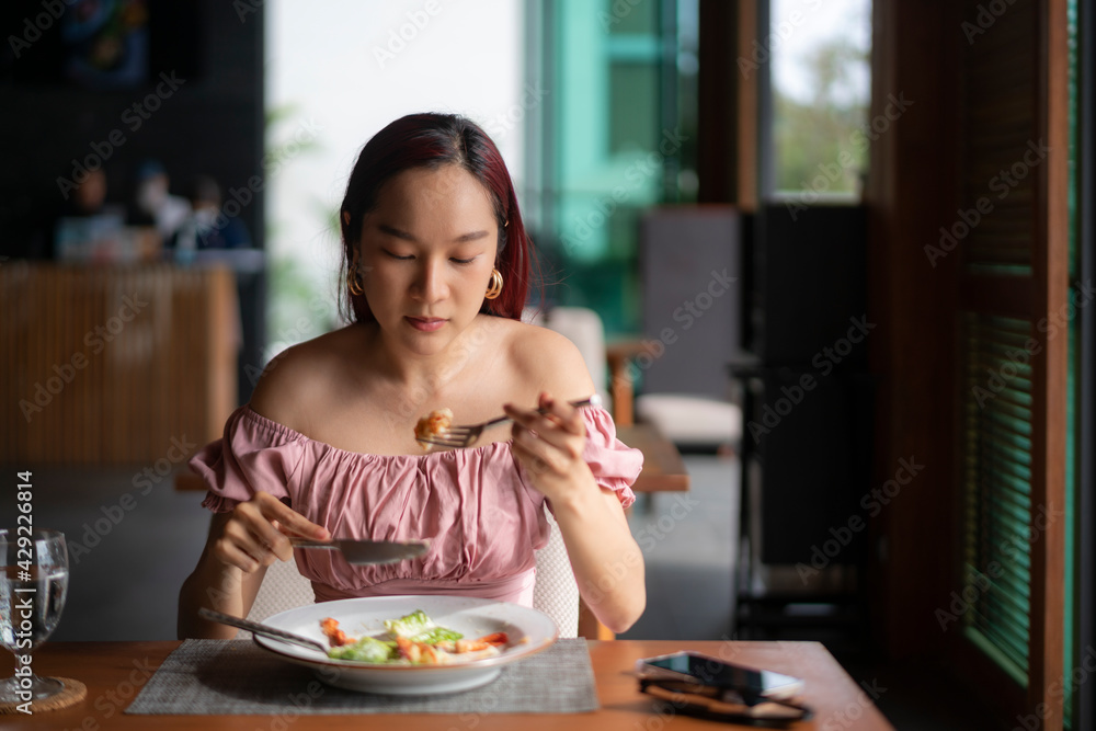 Young Asian woman eating healthy food in hotel restaurant on her vacation day. travel lifestyle concept Young Asian woman eating healthy food in hotel restaurant on her vacation day. travel lifestyle concept
