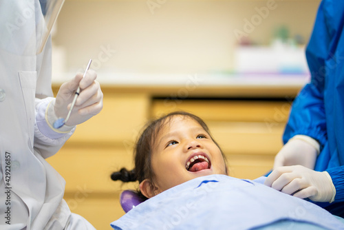 Asian dentist Bump fists with little Asian girl after check up teeth healthy in Dental's office. Dental care, Medical care, Lifestyle, Dental clinic or dental procedure concepts