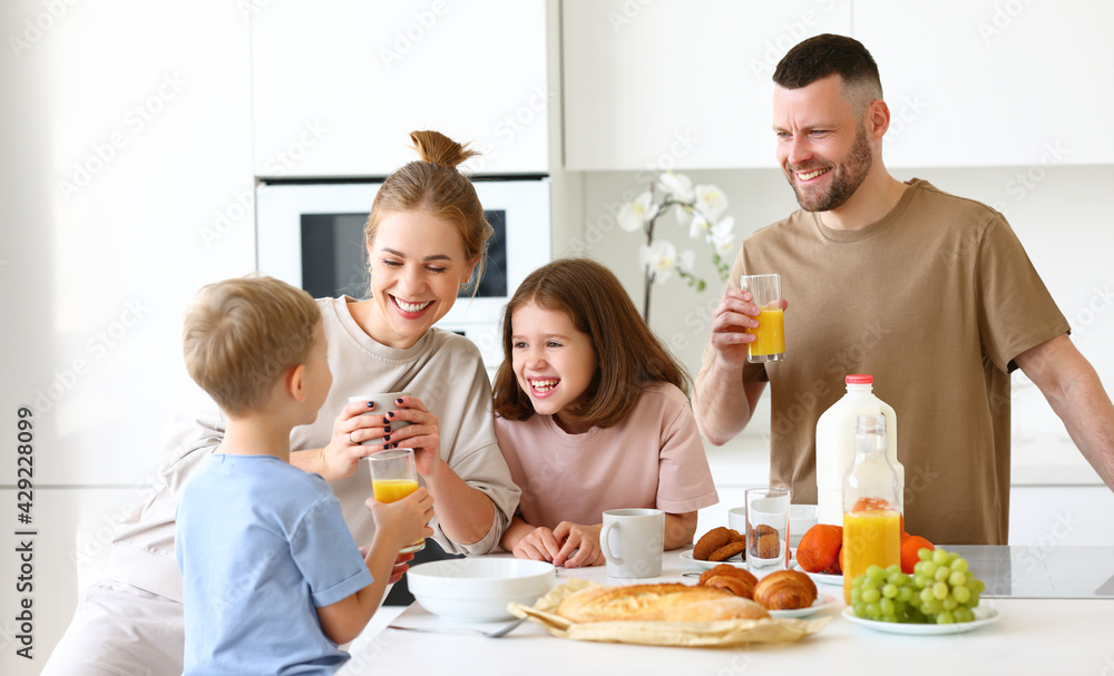 Young happy family having healthy breakfast in morning at home