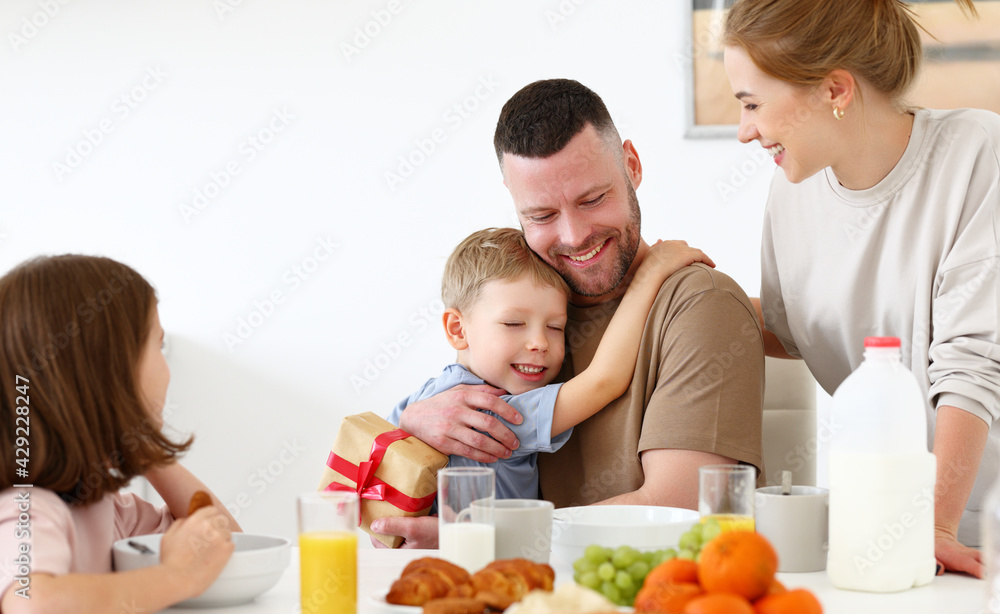 Happy family celebrating Fathers day together while having breakfast in kitchen at home Happy family celebrating Fathers day together while having breakfast in kitchen at home