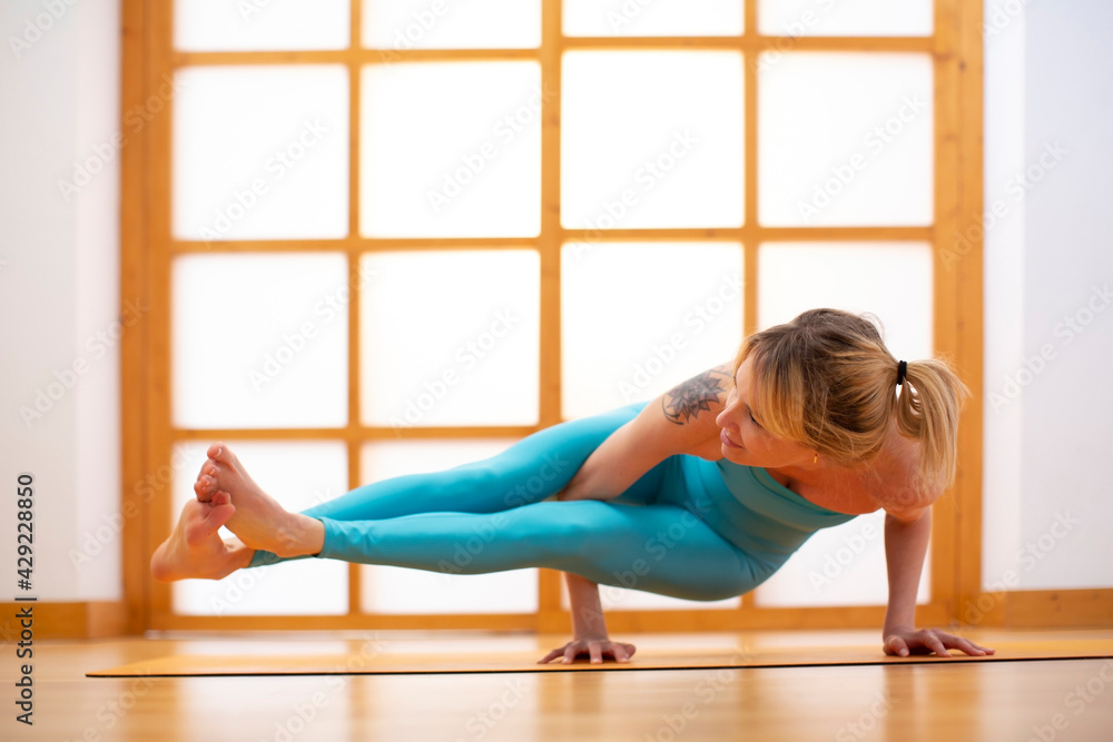 Fototapeta premium Young woman practicing yoga in a Japanese style room