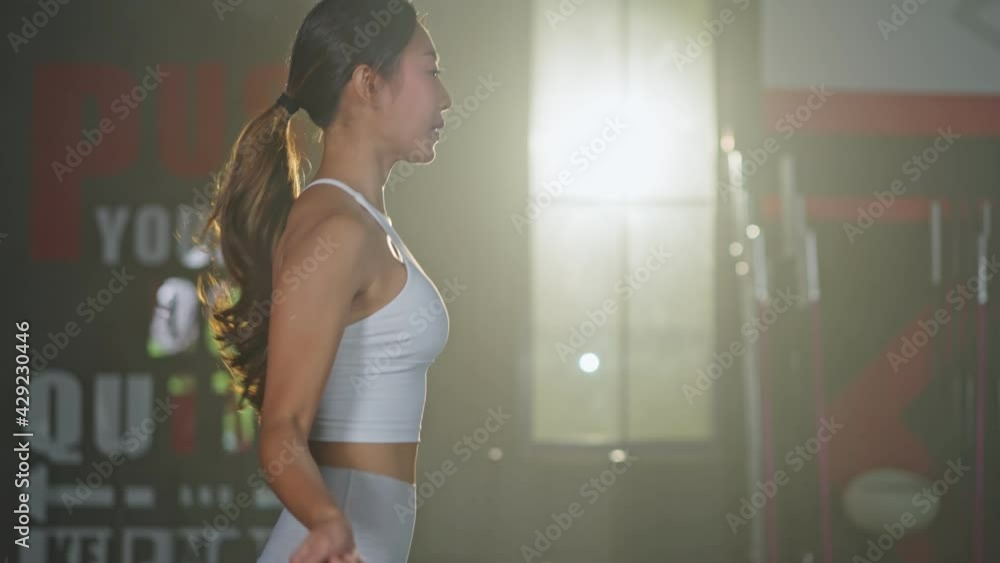 Asian young girl doing cardio exercise by skipping rope in the gym.