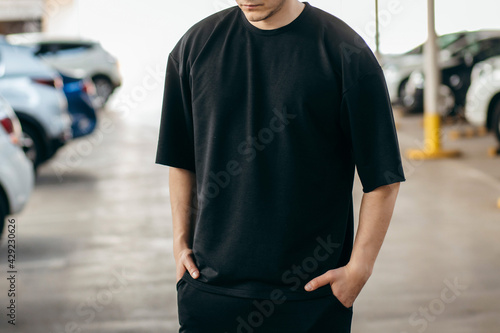 Man wearing black blank t-shirt with space for your logo or design. Mock up photo