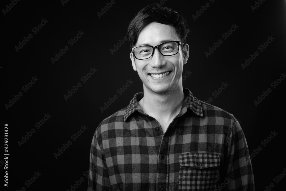 Young handsome Asian man against black background Young handsome Asian man against black background