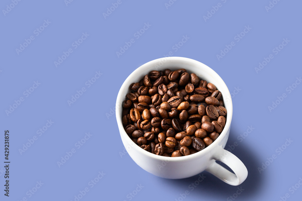 White coffee cup with coffee beans on violet backgrund. Copy space White coffee cup with coffee beans on violet backgrund. Copy space