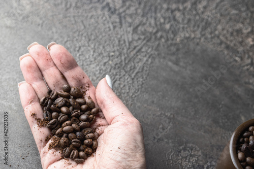 Woman hand holding freshly roasted coffee beans.