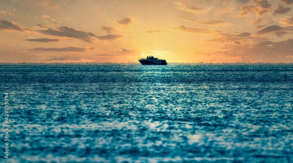 Fototapeta premium sunset in the sea with a boat