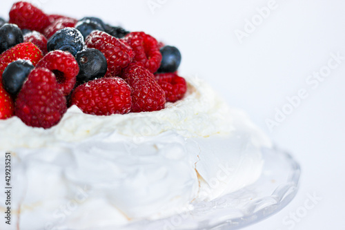 Pavlova cake with meringue, cream and red berries