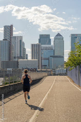 July 2020. London. man running and looking at Canary Wharf,London, England