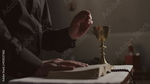 Wallpaper Mural Medium shot of unrecognizable pastor wearing black robe standing at altar and preaching sermon in Christian church during Eucharistic rite Torontodigital.ca