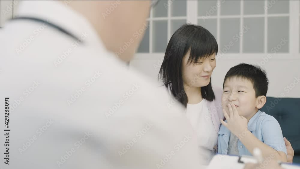 Happy asian woman and little boy talking to child psychologist, family therapy
