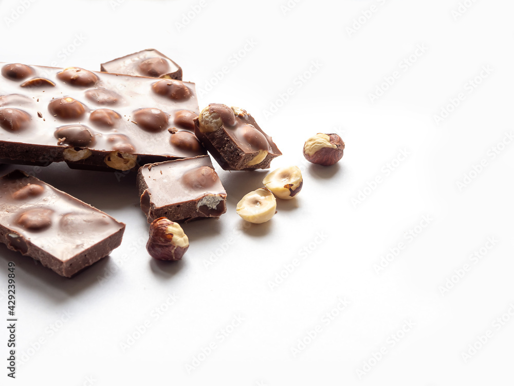 Delicious milk chocolate bars with nuts, on a white background. Delicious milk chocolate bars with nuts, on a white background.