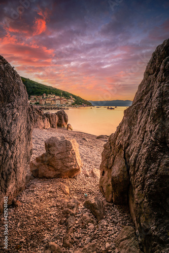 Rock view of Mošćenička Draga in Croatia. Sunrise on the beach, the view goes between two rocks over the sea to Moscenicka Draga in the morning mood photo