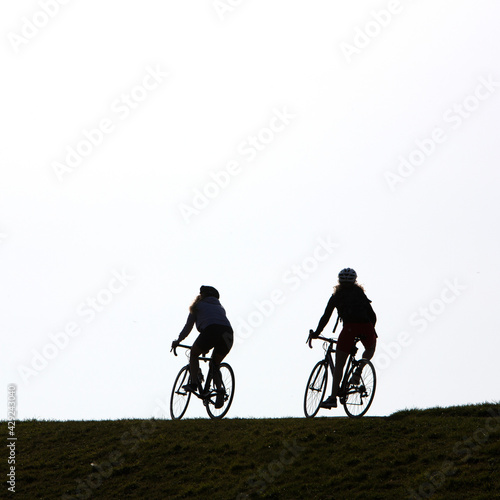 two women on bike on top of dike in holland