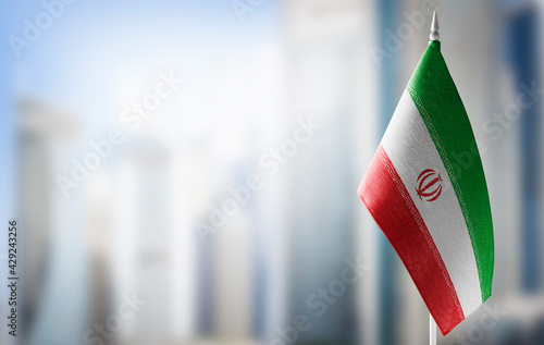 A small flag of Iran on the background of a blurred background