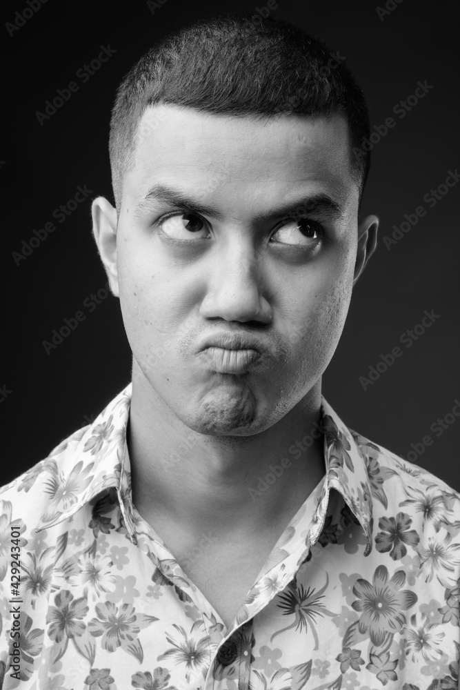 Obraz premium Young multi-ethnic Asian tourist man against brown background