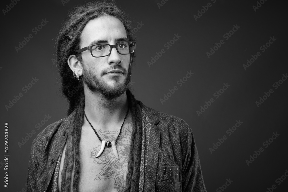 Fototapeta premium Young handsome Hispanic man with dreadlocks in black and white
