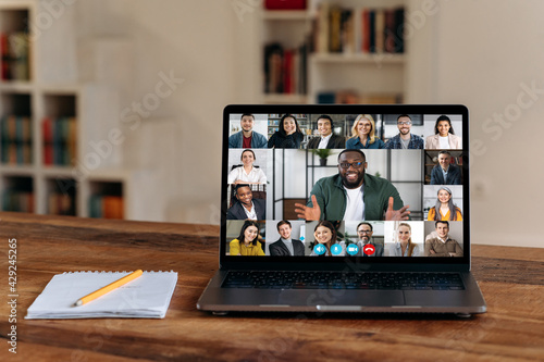 Online video communication. View at laptop screen with confident african american businessman or mentor conducts video meeting, business briefing with successful multiracial colleagues
