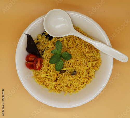 Cooked turmeric jasmine rice with powdered curcumin or Haldi, Indian food, indian basmati rice homemade with tomato and Cardamom.