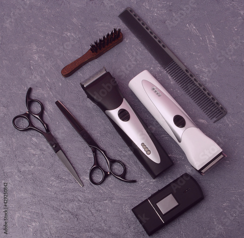 Set of Professional Barber Tools with Combs, Scissors, Hair Clipper, Shaver and Brush on Gray Background. Top View Mock Up