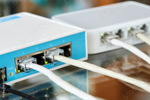 Ethernet cables connected to Desktop Switch and routerboard. Close-up, selective focus photo