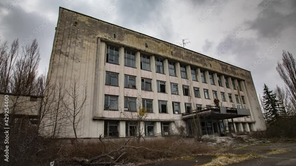 Pripyat, Ukraine - 15 April 2021. Chernobyl exclusion zone. Landscape timelapse footage of an abandoned city. Administration building 'Complex' with radiation hazard sign. Pripyat, Ukraine - 15 April 2021. Chernobyl exclusion zone. Landscape timelapse footage of an abandoned city. Administration building 'Complex' with radiation hazard sign.